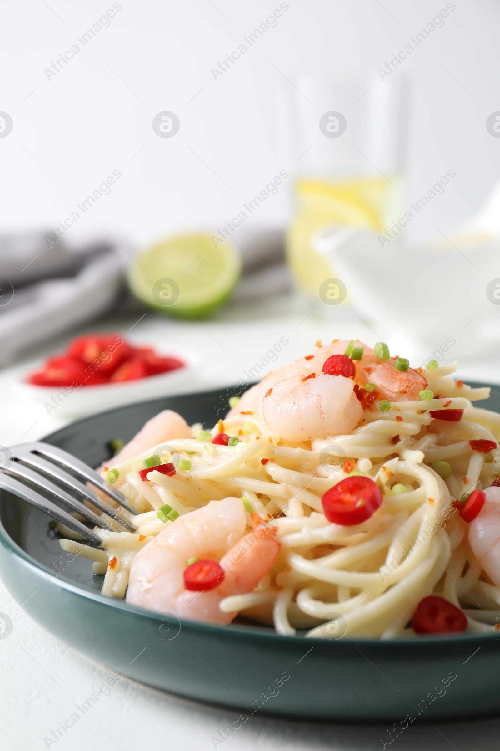 Photo of Delicious pasta with shrimps, green onion and chili pepper on white table, closeup