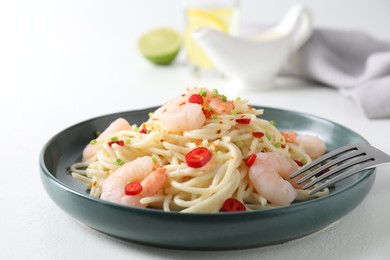 Photo of Delicious pasta with shrimps, green onion and chili pepper on white table, closeup