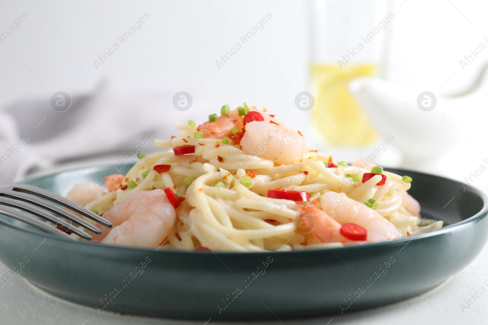 Photo of Delicious pasta with shrimps, green onion and chili pepper on white table, closeup