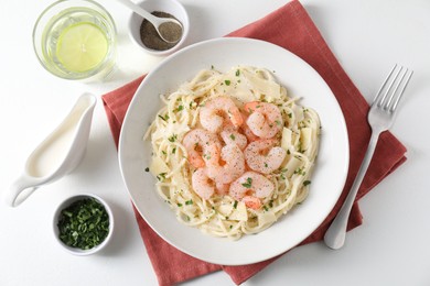 Photo of Delicious pasta with shrimps and cheese served on white table, top view