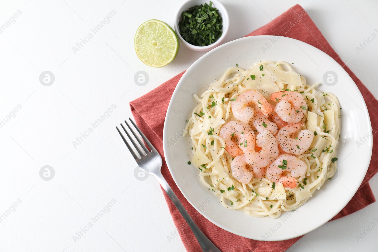 Photo of Delicious pasta with shrimps and cheese served on white table, top view. Space for text