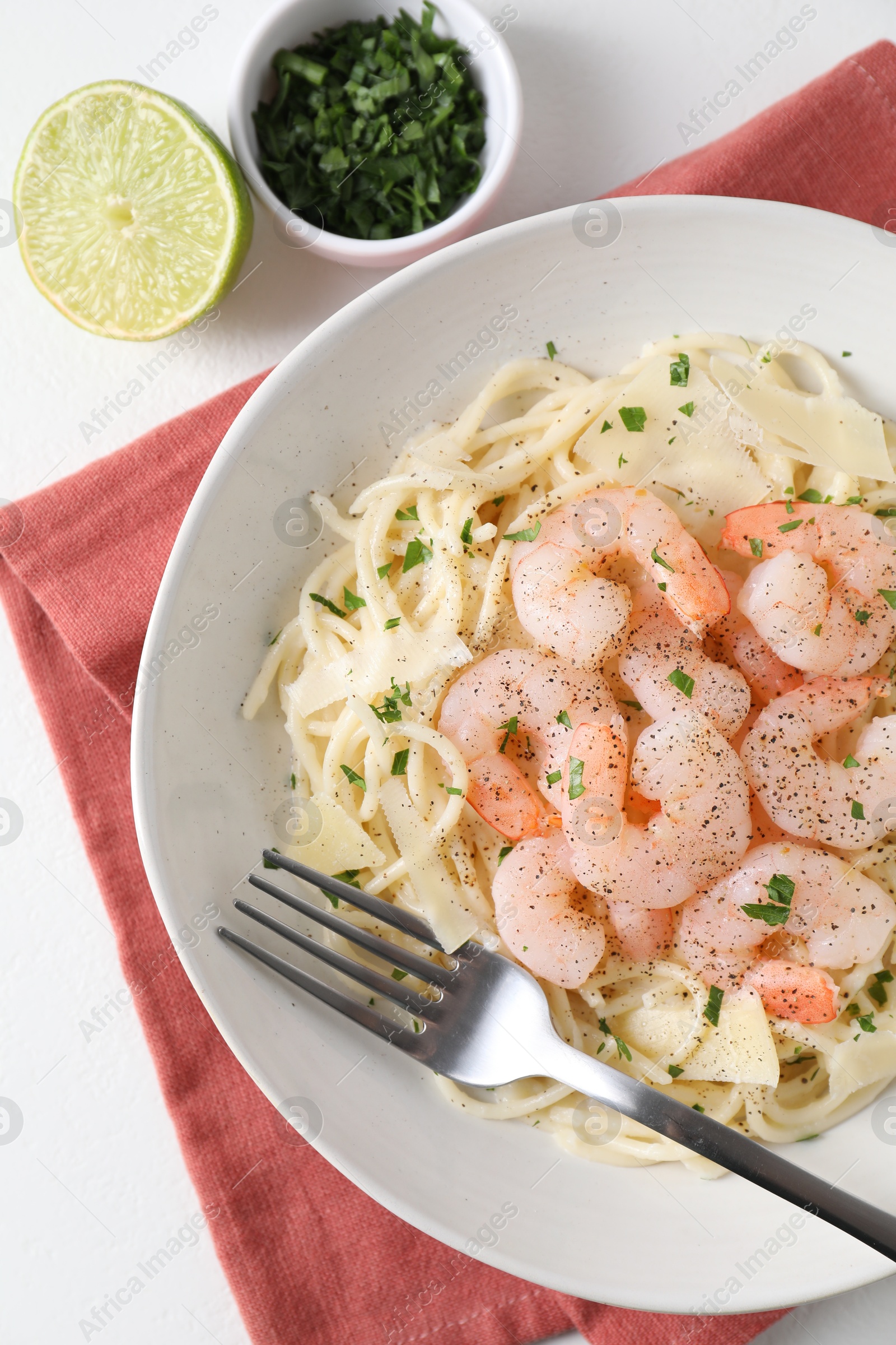 Photo of Delicious pasta with shrimps and cheese served on white table, top view