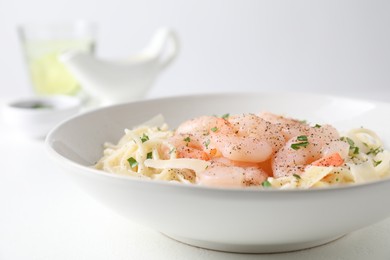 Photo of Delicious pasta with shrimps and cheese on white table, closeup