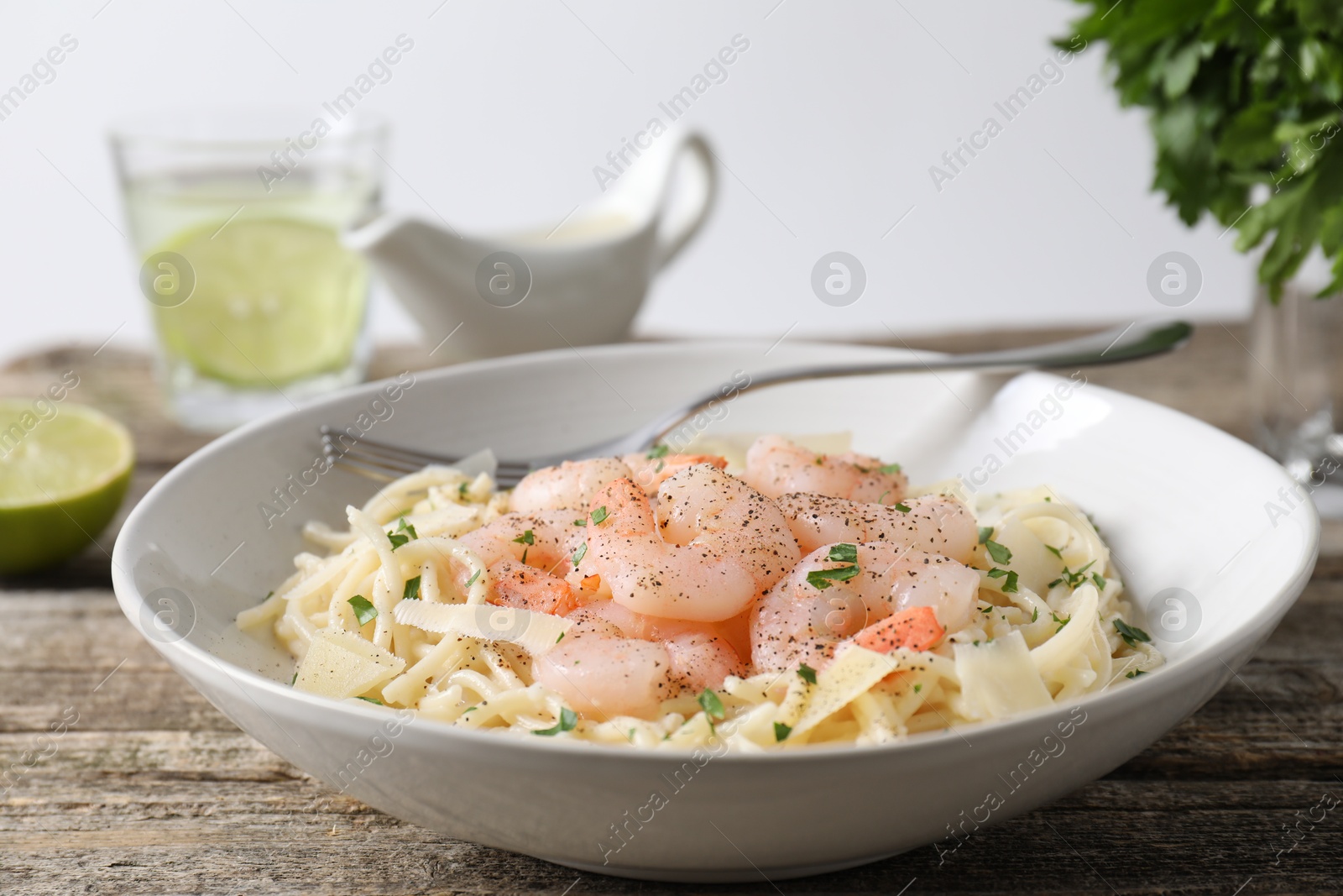 Photo of Delicious pasta with shrimps and cheese on wooden table, closeup