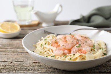 Photo of Delicious pasta with shrimps and cheese on wooden table, closeup