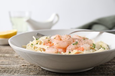 Photo of Delicious pasta with shrimps and cheese on wooden table, closeup