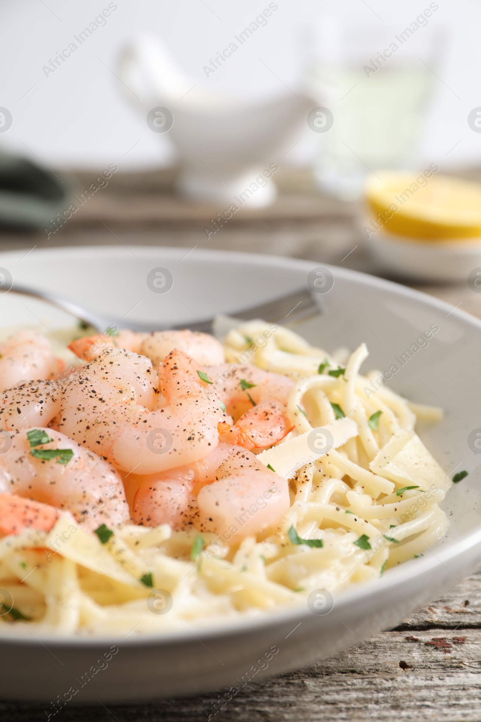 Photo of Delicious pasta with shrimps and cheese on wooden table, closeup