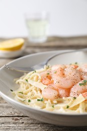 Photo of Delicious pasta with shrimps and cheese on wooden table, closeup