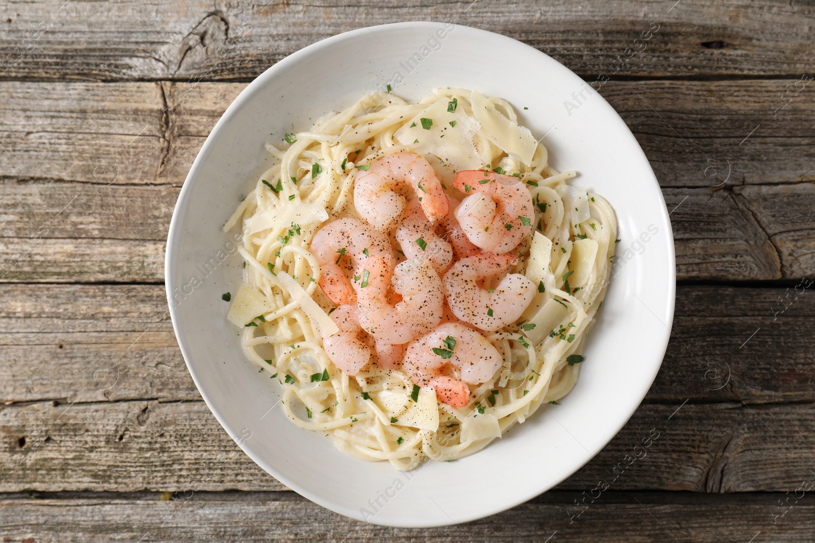 Photo of Delicious pasta with shrimps and cheese on wooden table