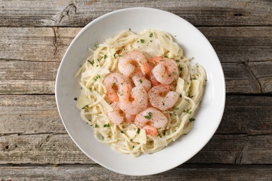 Delicious pasta with shrimps and cheese on wooden table