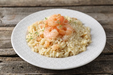 Photo of Delicious risotto with shrimps and cheese on wooden table, closeup