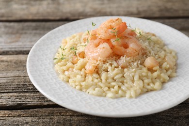 Delicious risotto with shrimps and cheese on wooden table, closeup