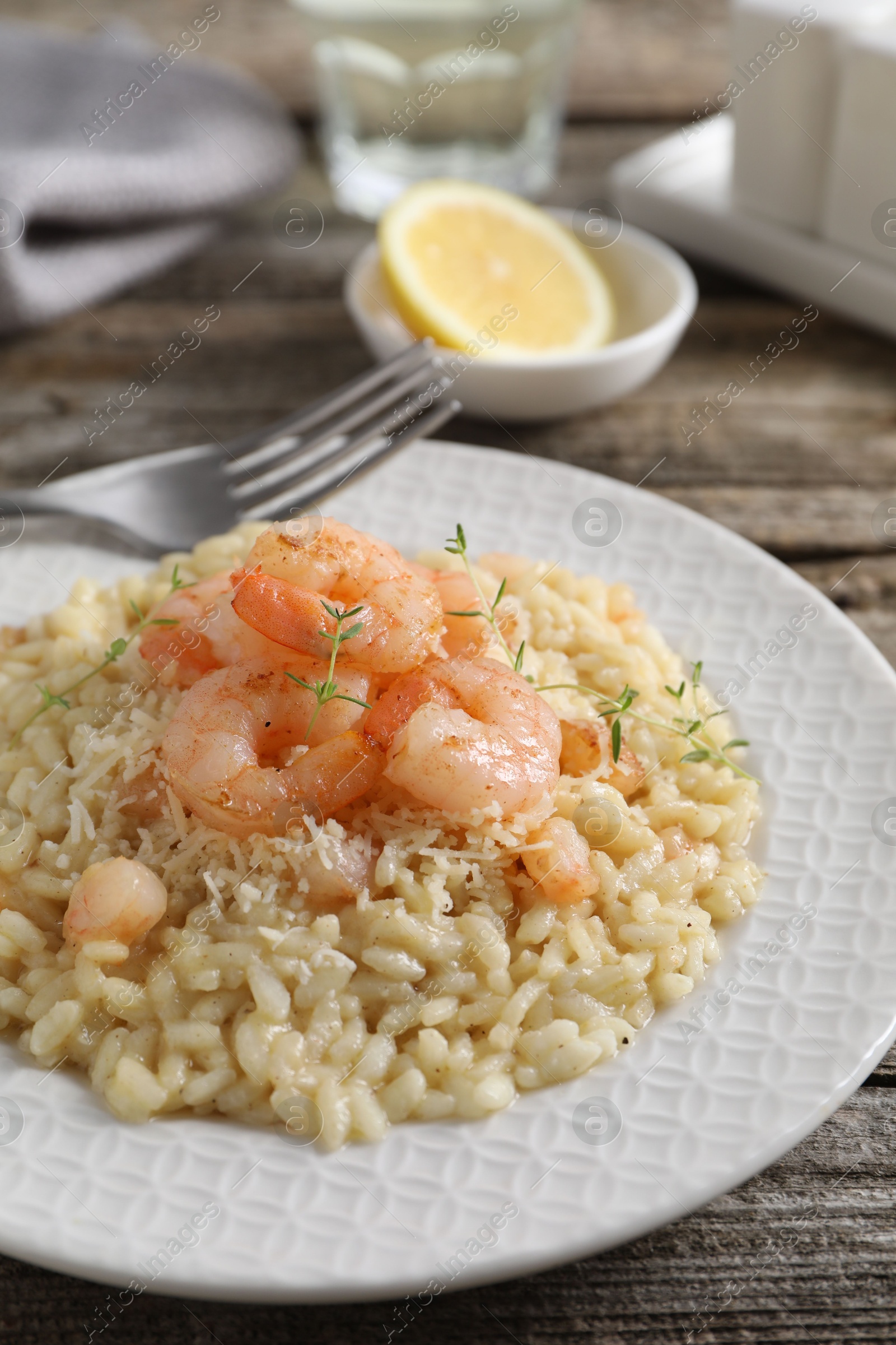 Photo of Delicious risotto with shrimps and cheese on wooden table, closeup