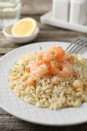 Photo of Delicious risotto with shrimps and cheese on wooden table, closeup