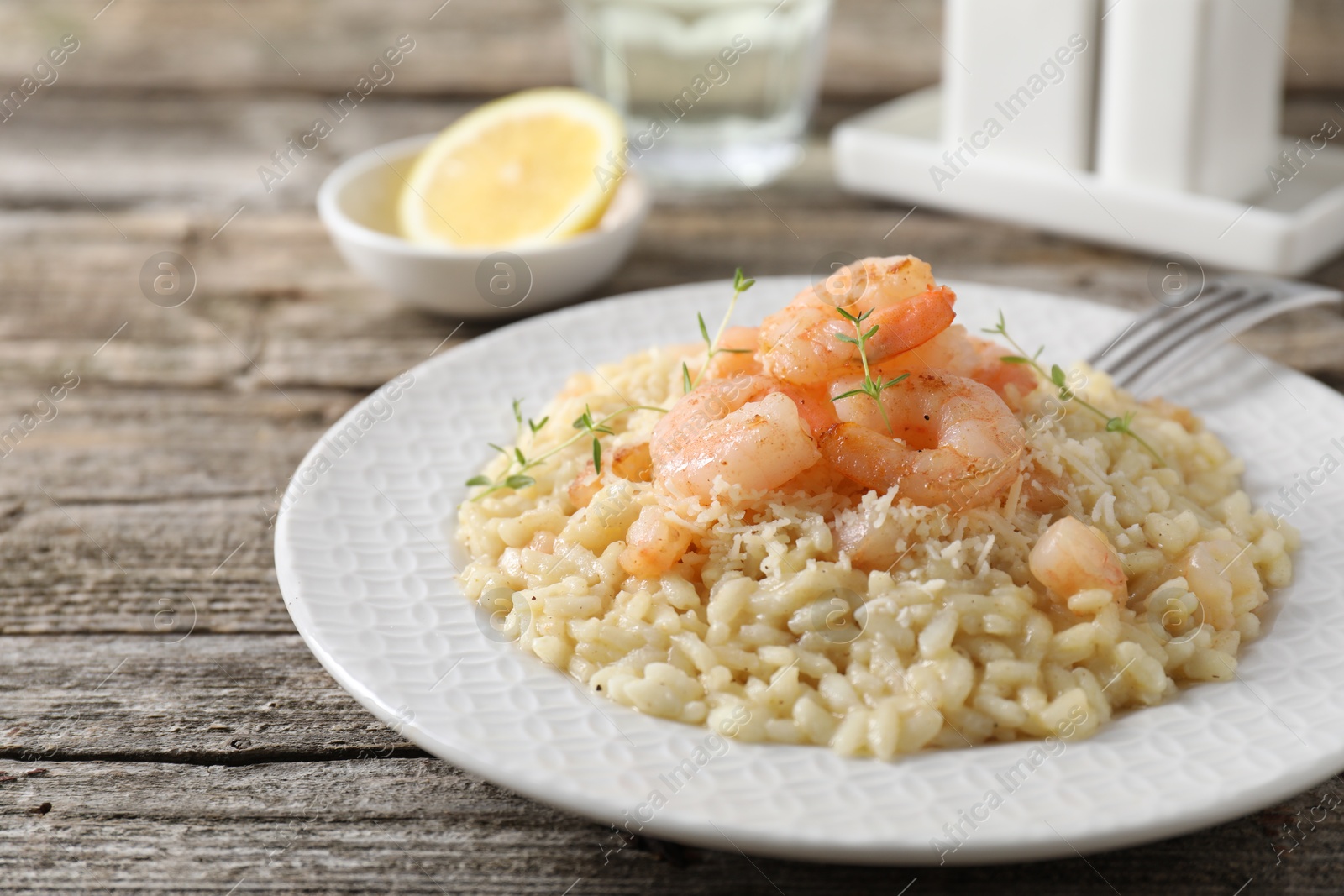 Photo of Delicious risotto with shrimps and cheese on wooden table, closeup