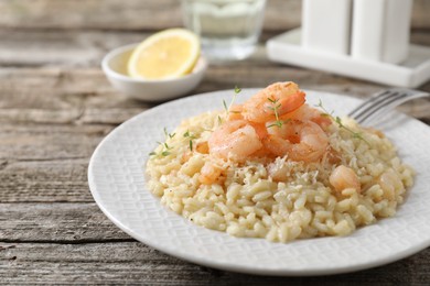 Photo of Delicious risotto with shrimps and cheese on wooden table, closeup