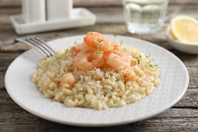 Photo of Delicious risotto with shrimps and cheese on wooden table, closeup