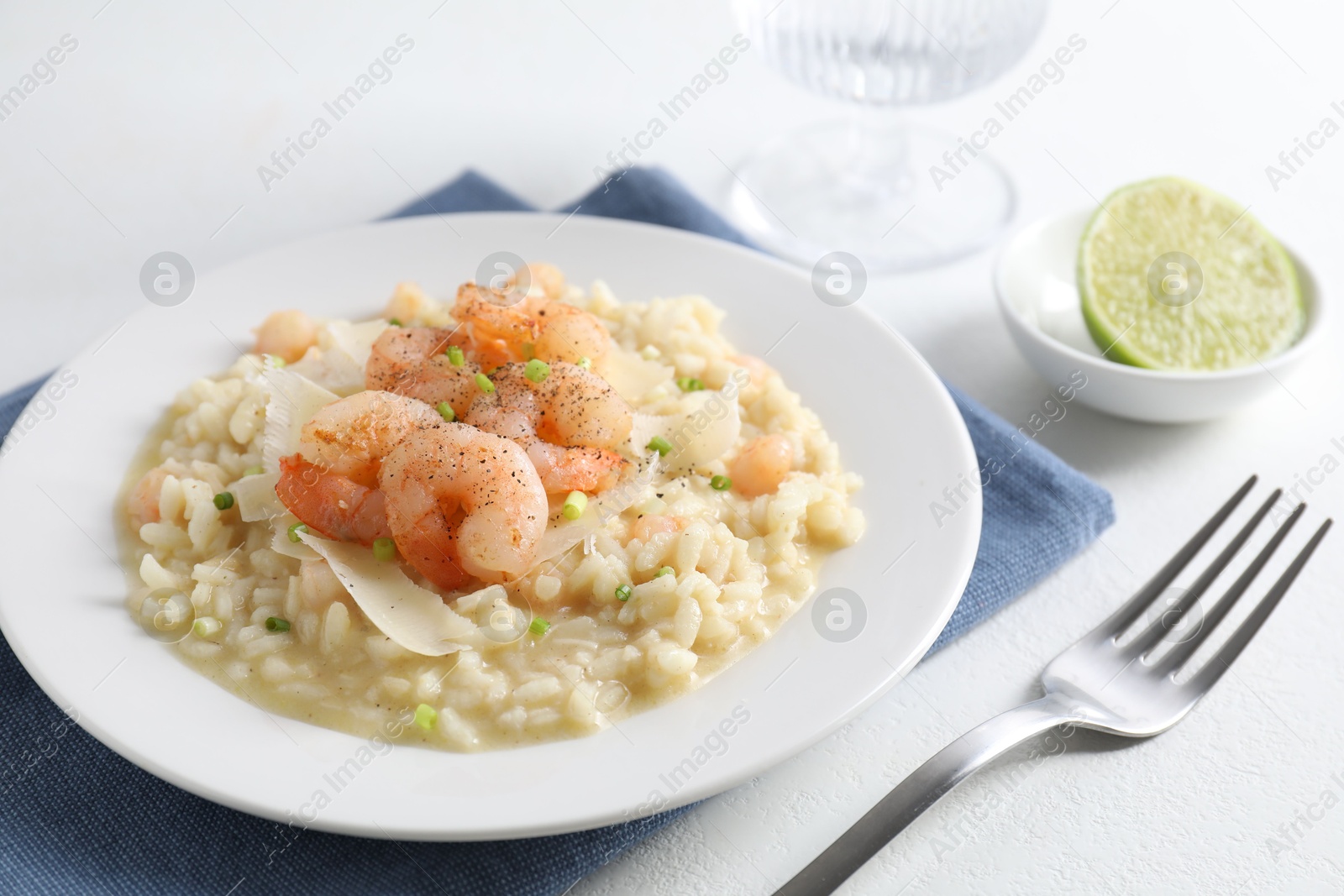 Photo of Delicious risotto with shrimps and cheese on white table, closeup