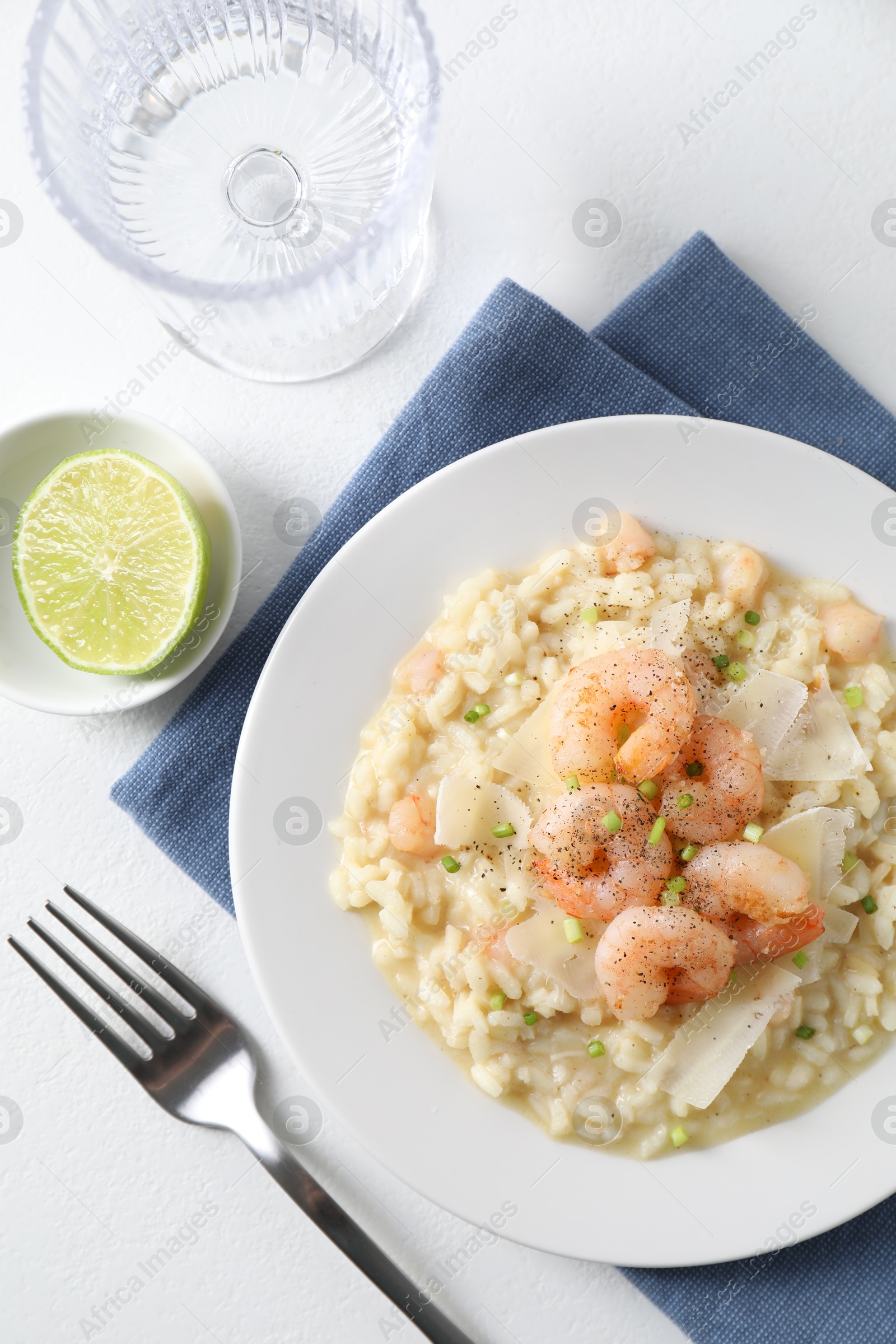 Photo of Delicious risotto with shrimps and cheese on white table, top view