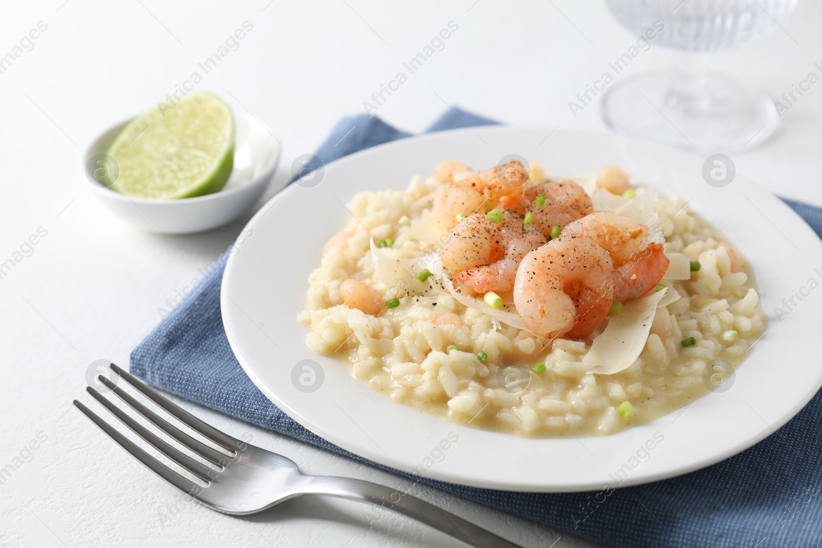 Photo of Delicious risotto with shrimps and cheese on white table, closeup