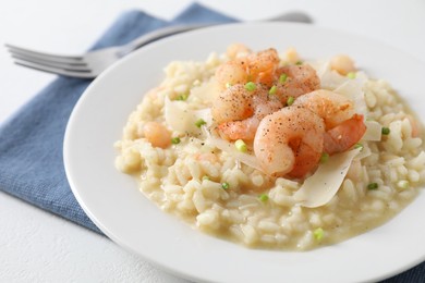 Photo of Delicious risotto with shrimps and cheese on white table, closeup