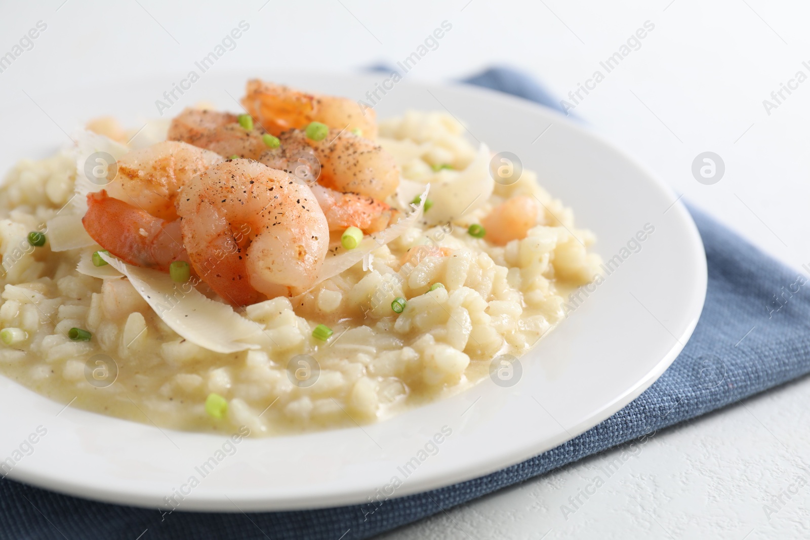 Photo of Delicious risotto with shrimps and cheese on white table, closeup