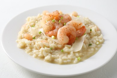 Photo of Delicious risotto with shrimps and cheese on white table, closeup