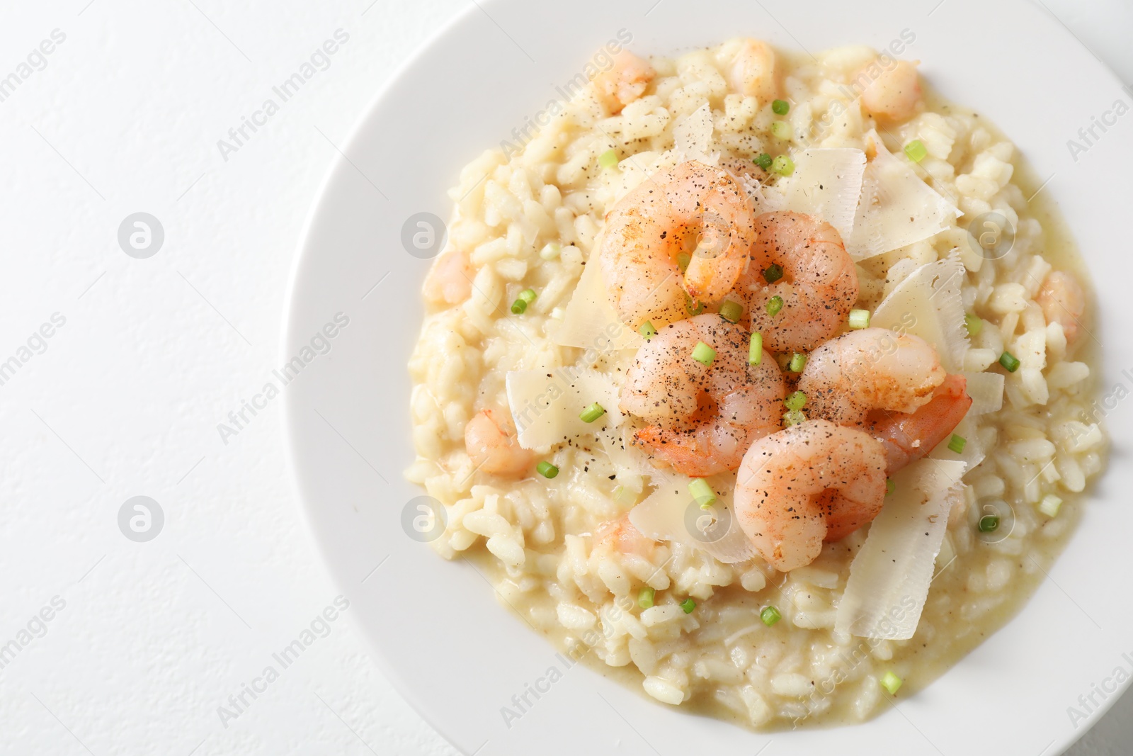 Photo of Delicious risotto with shrimps and cheese on white table, top view