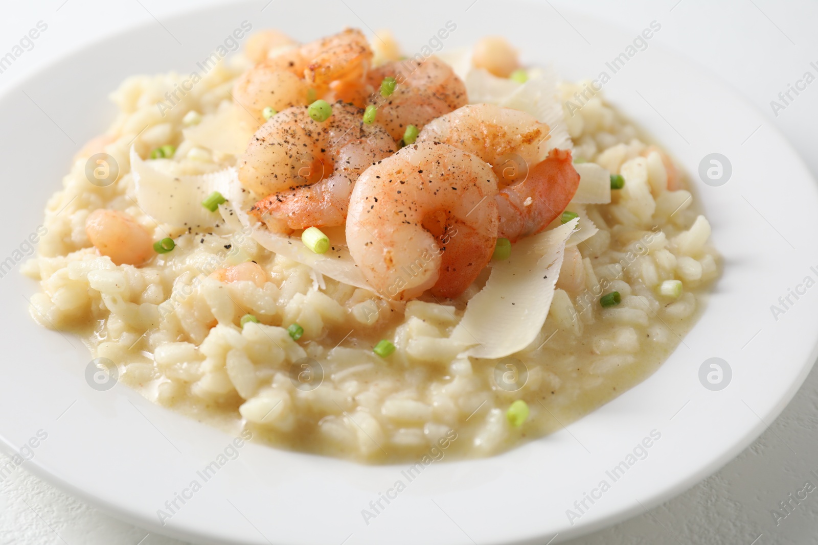 Photo of Delicious risotto with shrimps and cheese on table, closeup