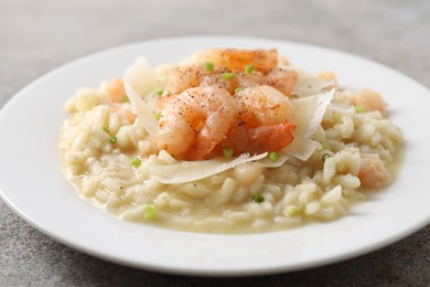 Photo of Delicious risotto with shrimps and cheese on grey table, closeup