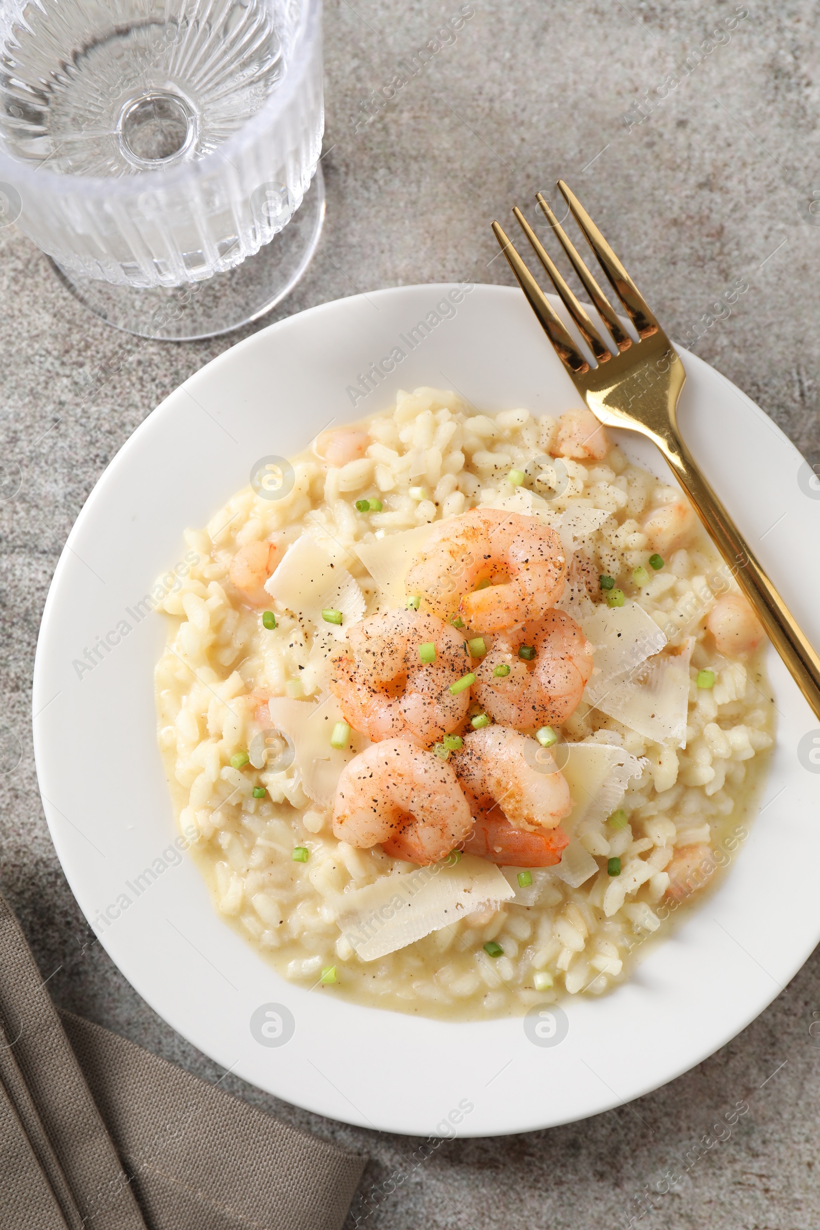 Photo of Delicious risotto with shrimps and cheese on grey table, top view