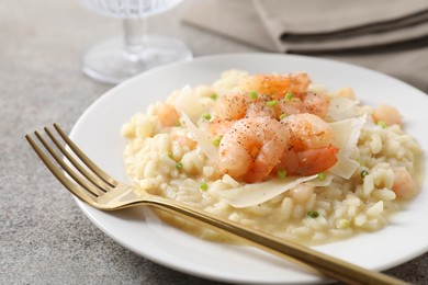 Photo of Delicious risotto with shrimps and cheese on grey table, closeup