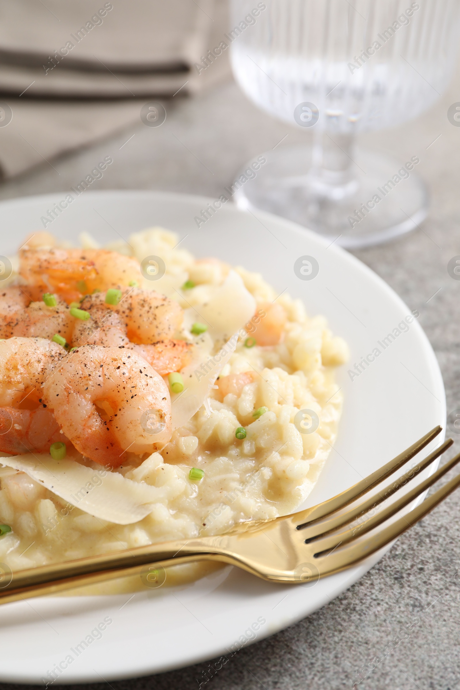 Photo of Delicious risotto with shrimps and cheese on grey table, closeup