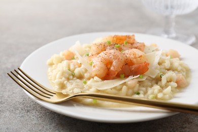 Photo of Delicious risotto with shrimps and cheese on grey table, closeup