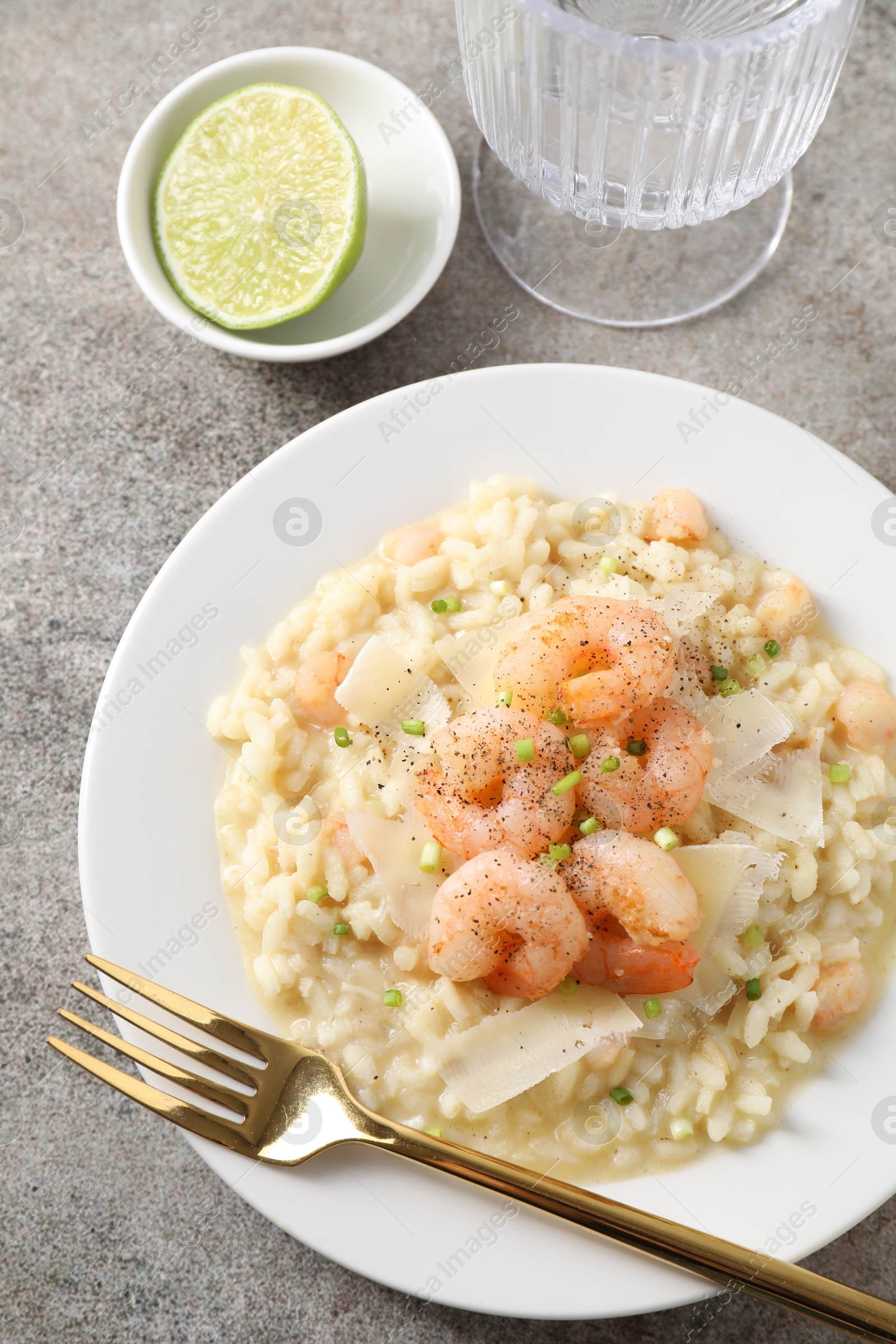 Photo of Delicious risotto with shrimps and cheese on grey table, top view