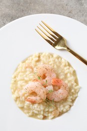 Photo of Delicious risotto with shrimps and cheese on grey table, top view