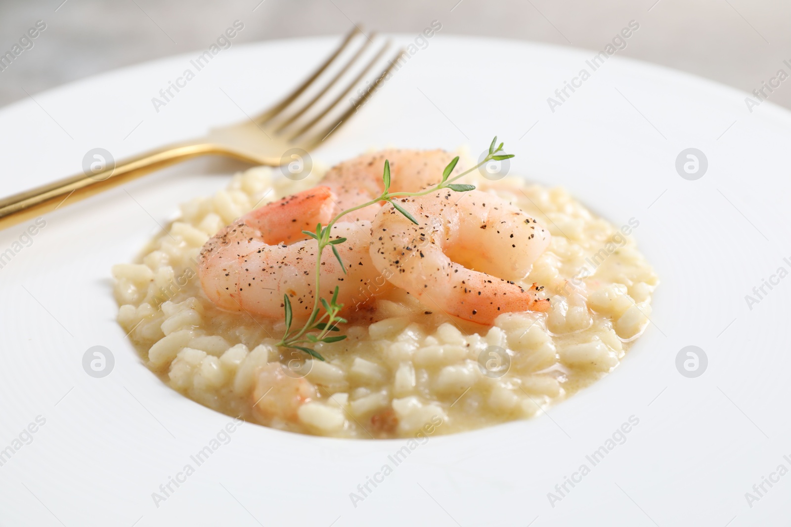 Photo of Delicious risotto with shrimps and cheese on plate, closeup