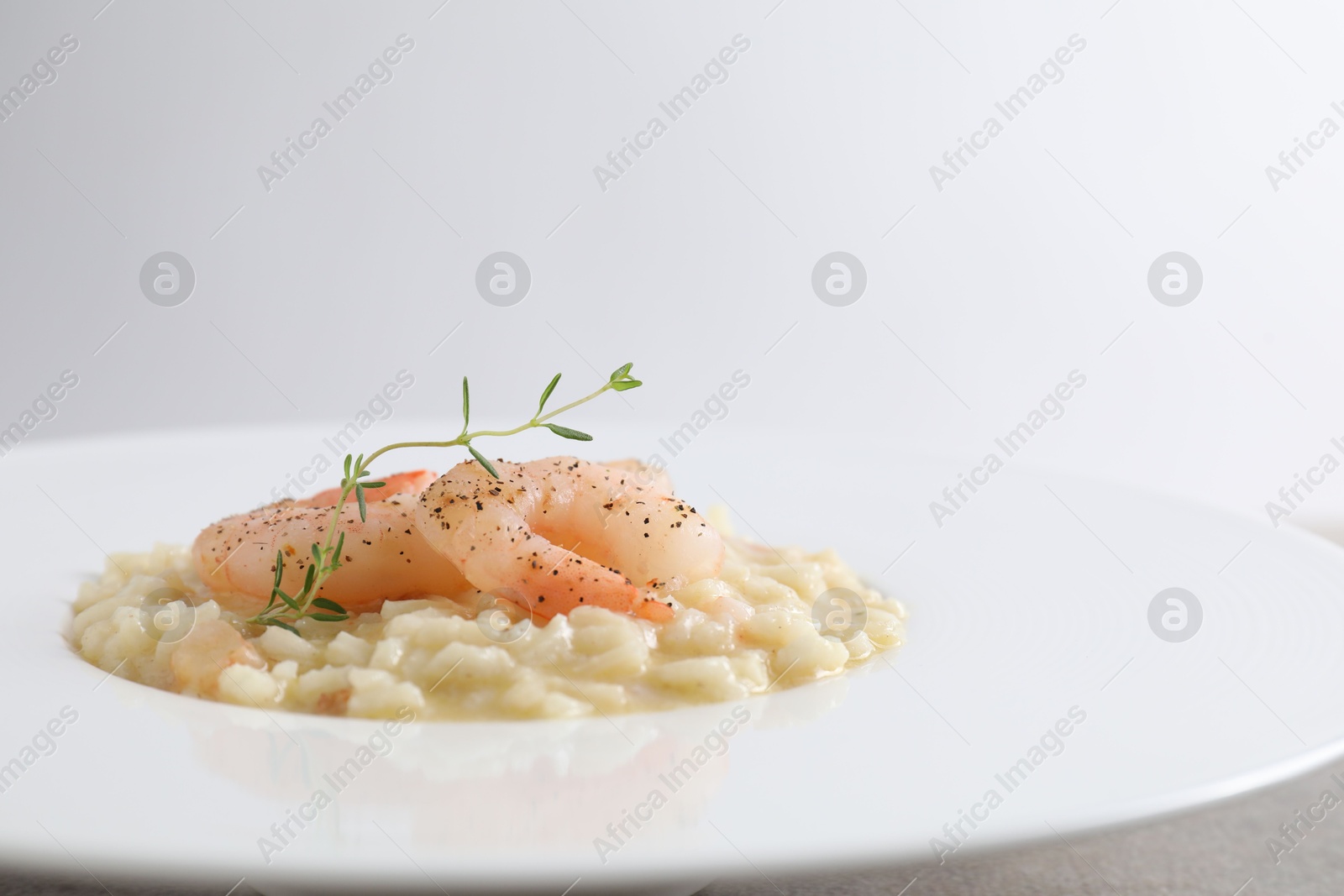 Photo of Delicious risotto with shrimps and cheese on table, closeup