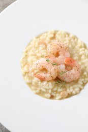 Photo of Delicious risotto with shrimps and cheese on plate, top view