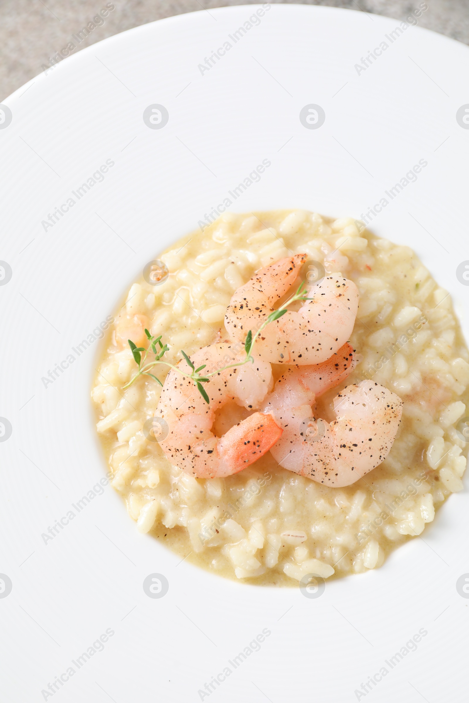 Photo of Delicious risotto with shrimps and cheese on plate, top view