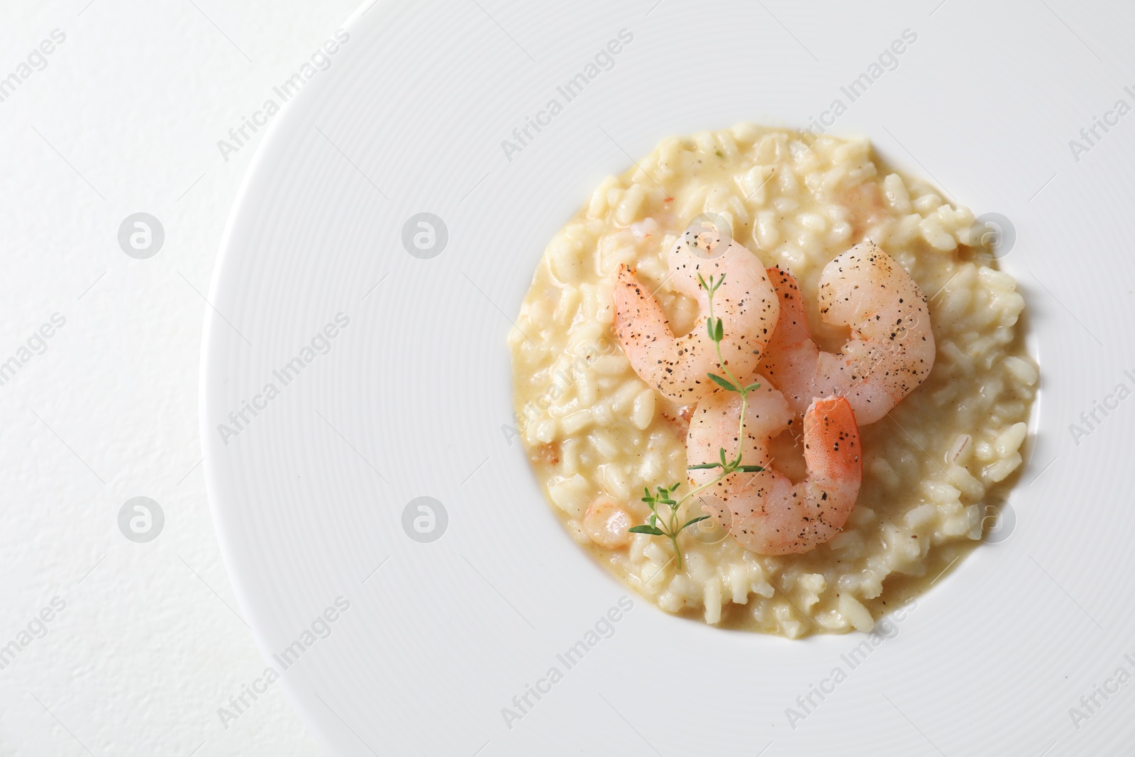 Photo of Delicious risotto with shrimps and cheese on white table, top view