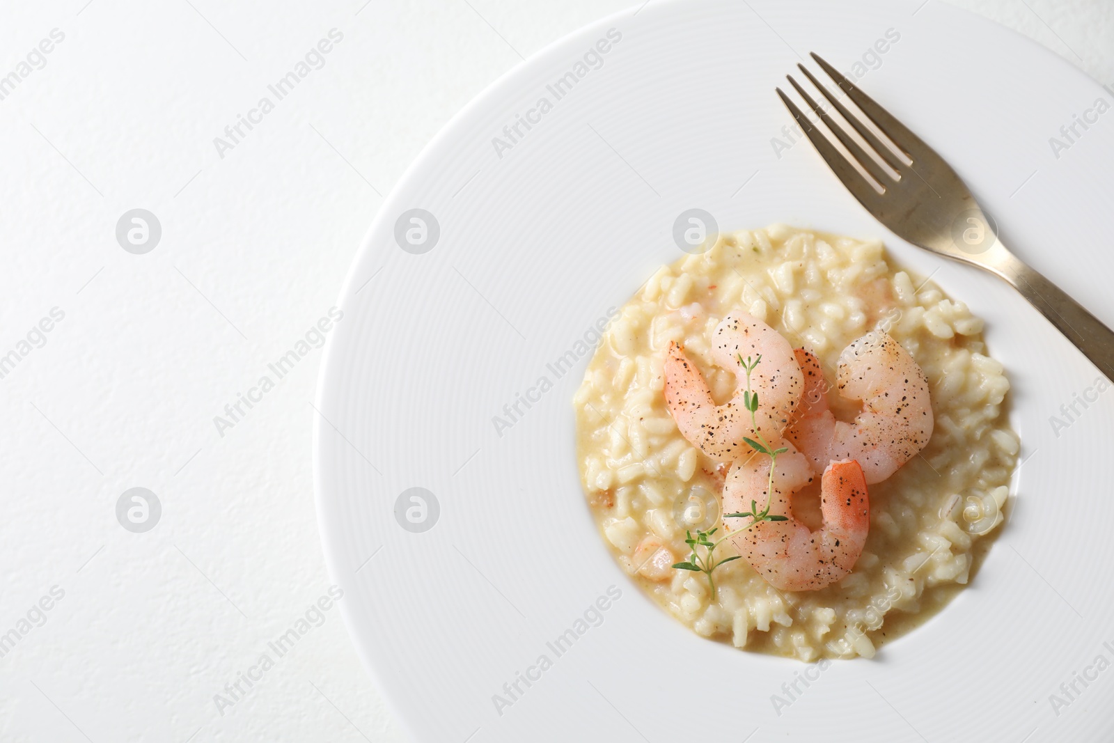 Photo of Delicious risotto with shrimps and cheese on white table, top view