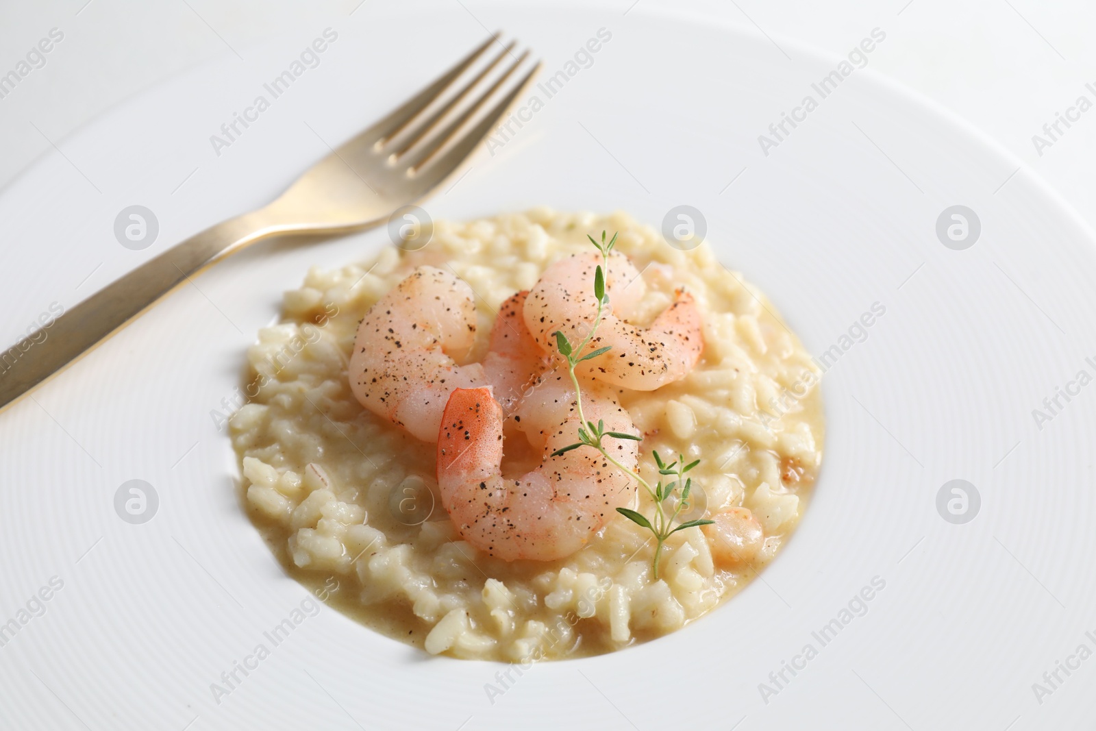 Photo of Delicious risotto with shrimps and cheese on plate, closeup