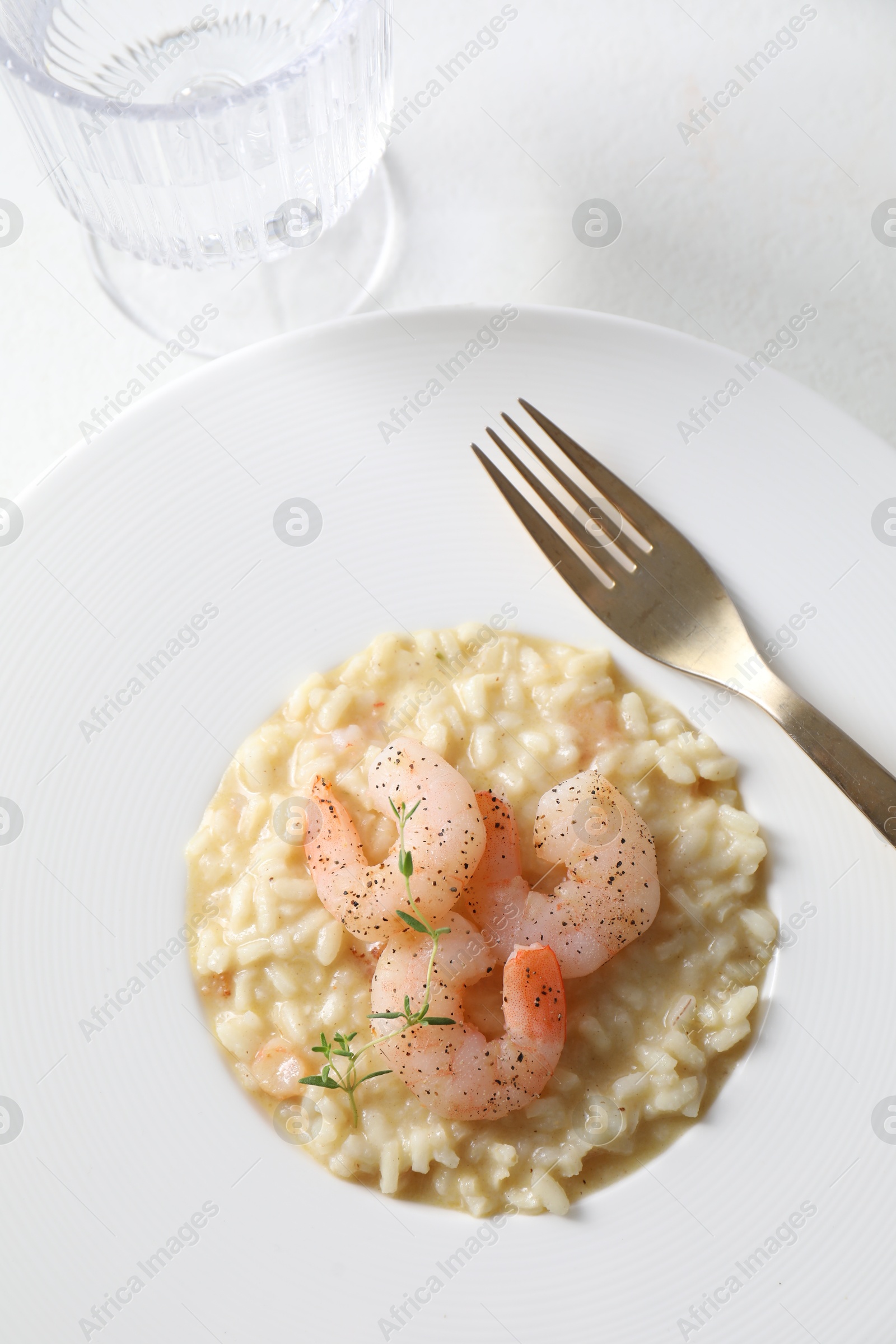 Photo of Delicious risotto with shrimps and cheese on white table, above view