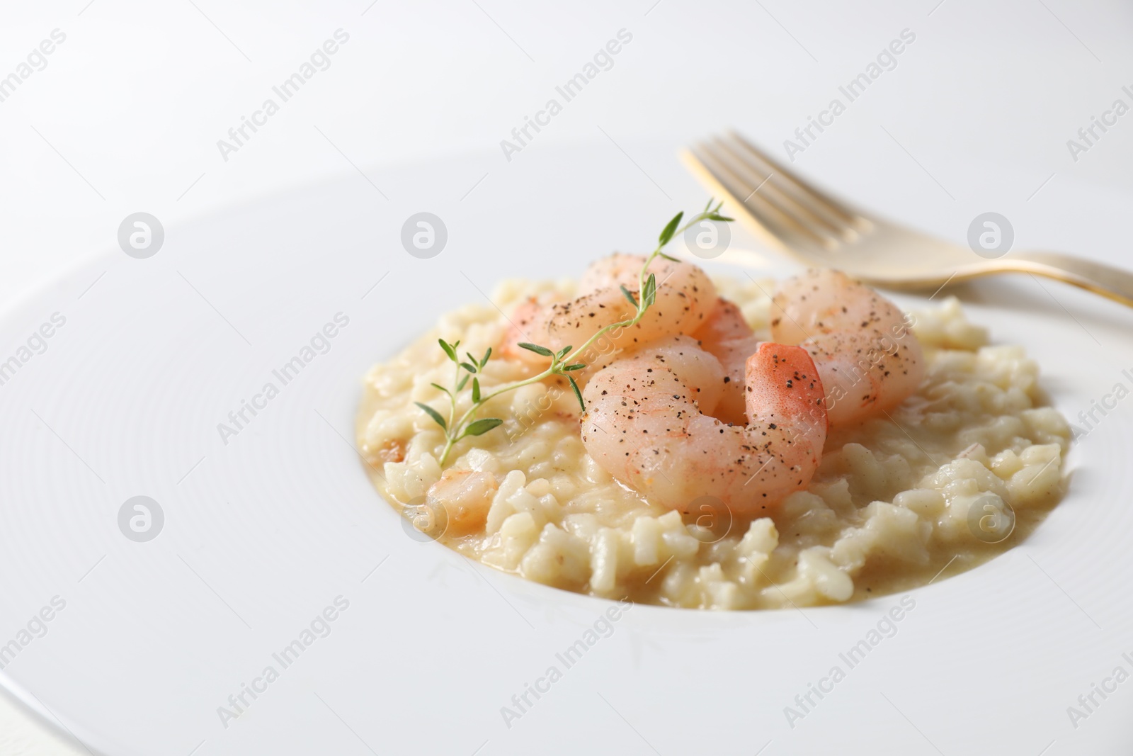 Photo of Delicious risotto with shrimps and cheese on plate, closeup