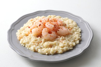 Photo of Delicious risotto with shrimps and cheese on white table, closeup