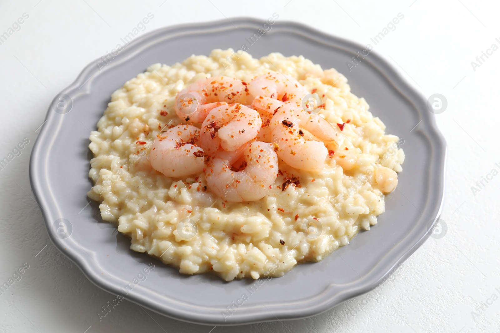 Photo of Delicious risotto with shrimps and cheese on white table, closeup