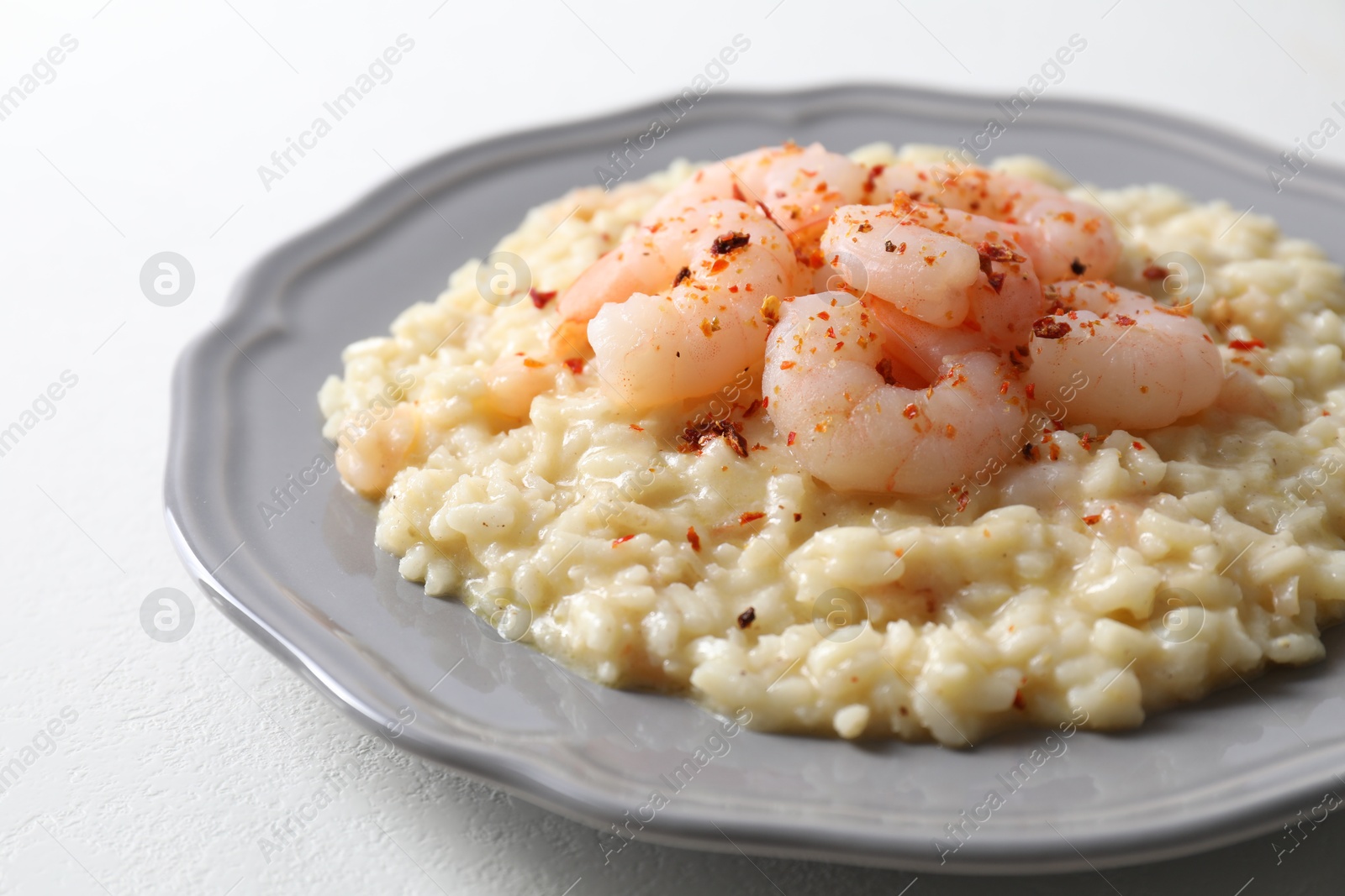 Photo of Delicious risotto with shrimps and cheese on white table, closeup