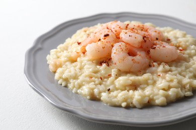 Photo of Delicious risotto with shrimps and cheese on white table, closeup