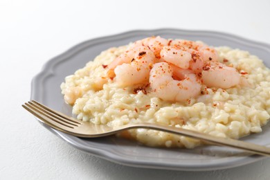 Photo of Delicious risotto with shrimps and cheese on white table, closeup